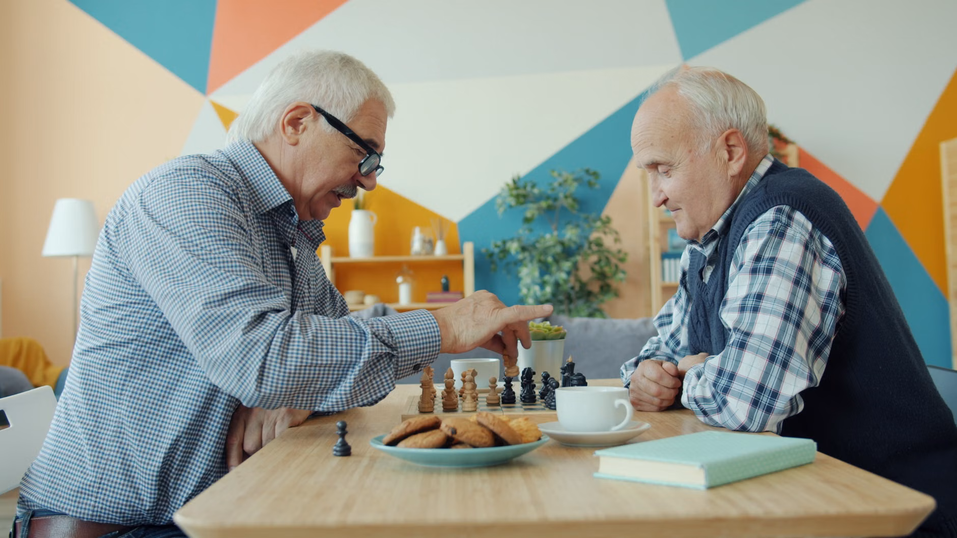 Strategic Thinking: How Basic Strategy Games Support Cognitive Health and Daily Decision-Making 2 Two seniors playing checkers with tea on the table.