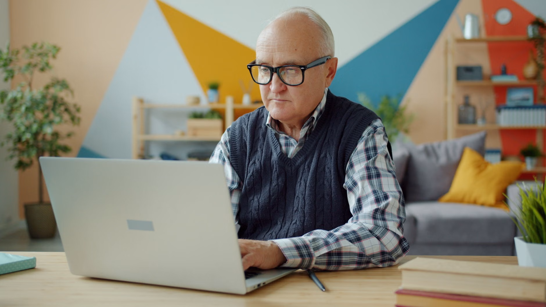 2026 Digital Pension Verification: A Practical Guide for Seniors 2 An older adult working on a laptop in a bright, organized home office.