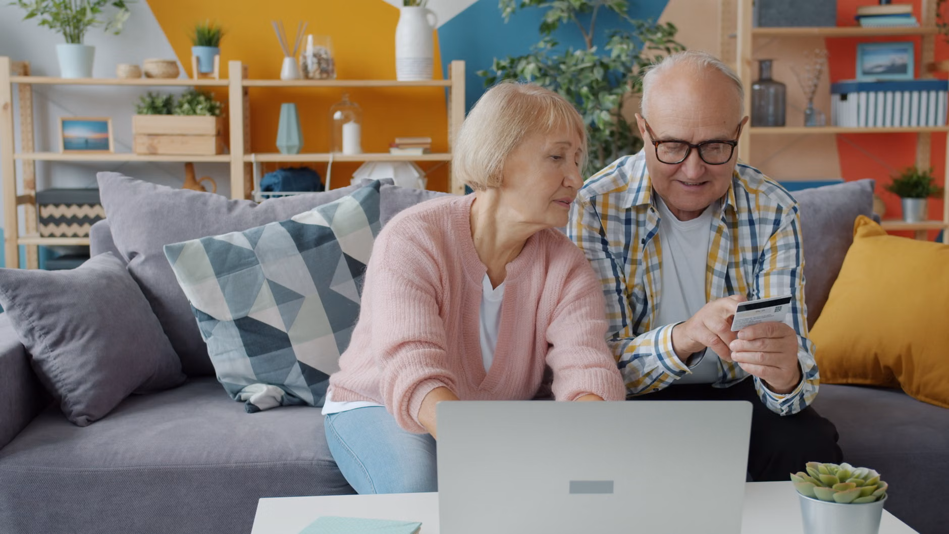 A group of older adults planning a trip using a digital device in a transit lounge.