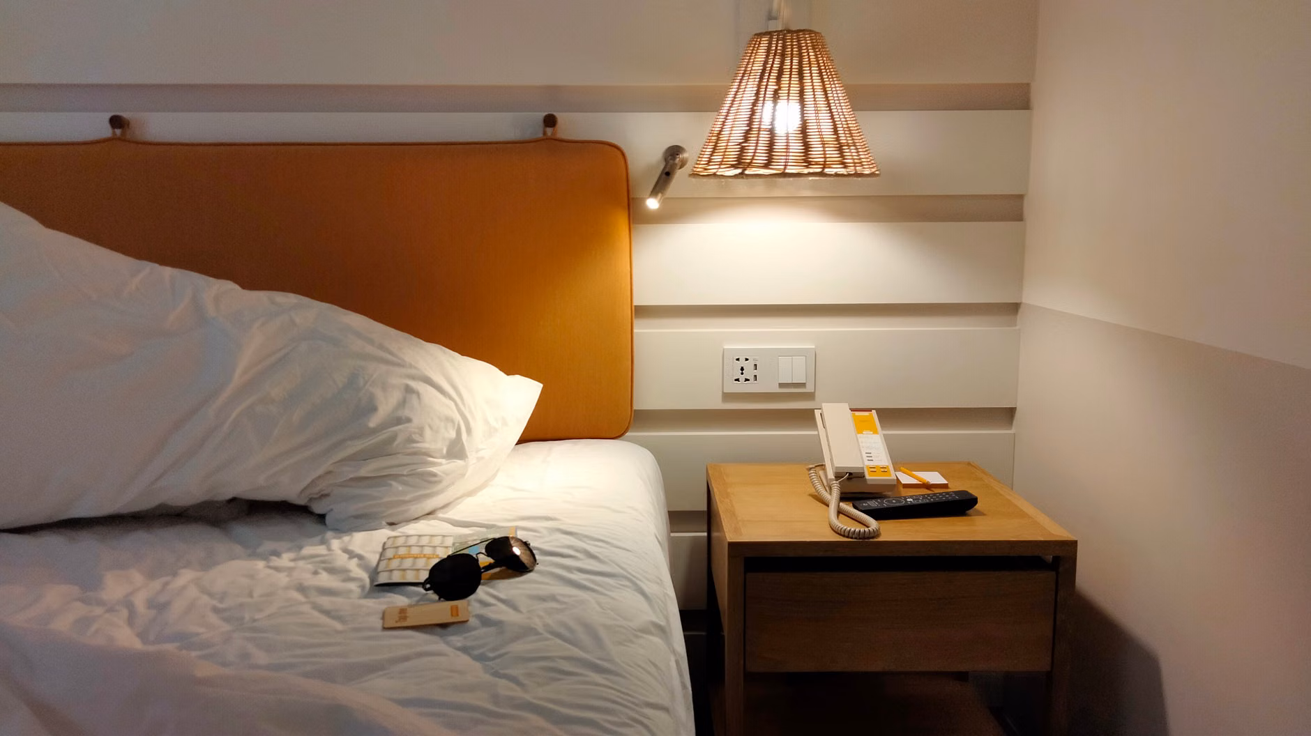 Headphones and a guidebook on a hotel room table.