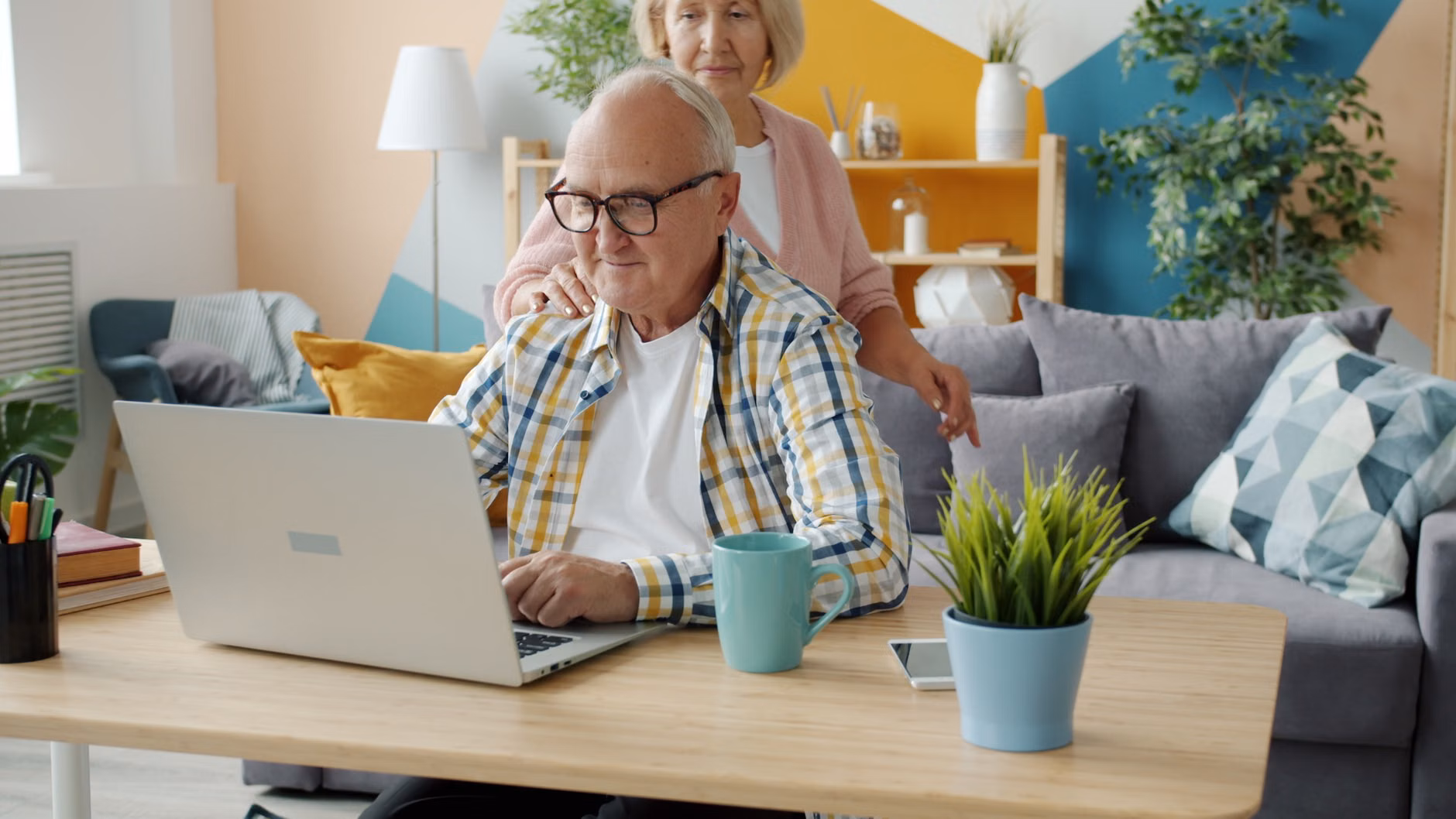 A couple using a computer to check their retirement benefit status.