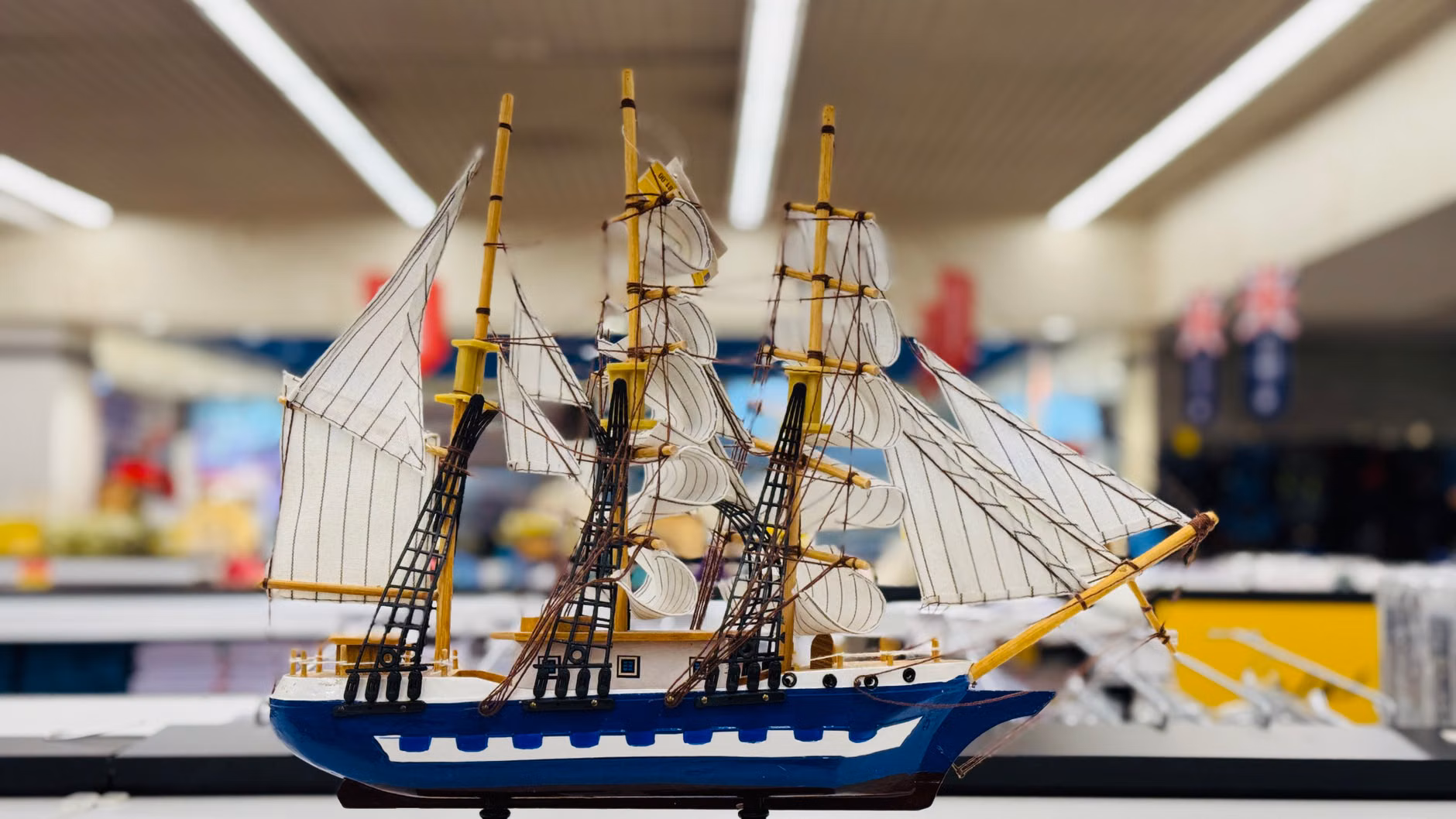A completed, detailed wooden model ship displayed on a shelf.