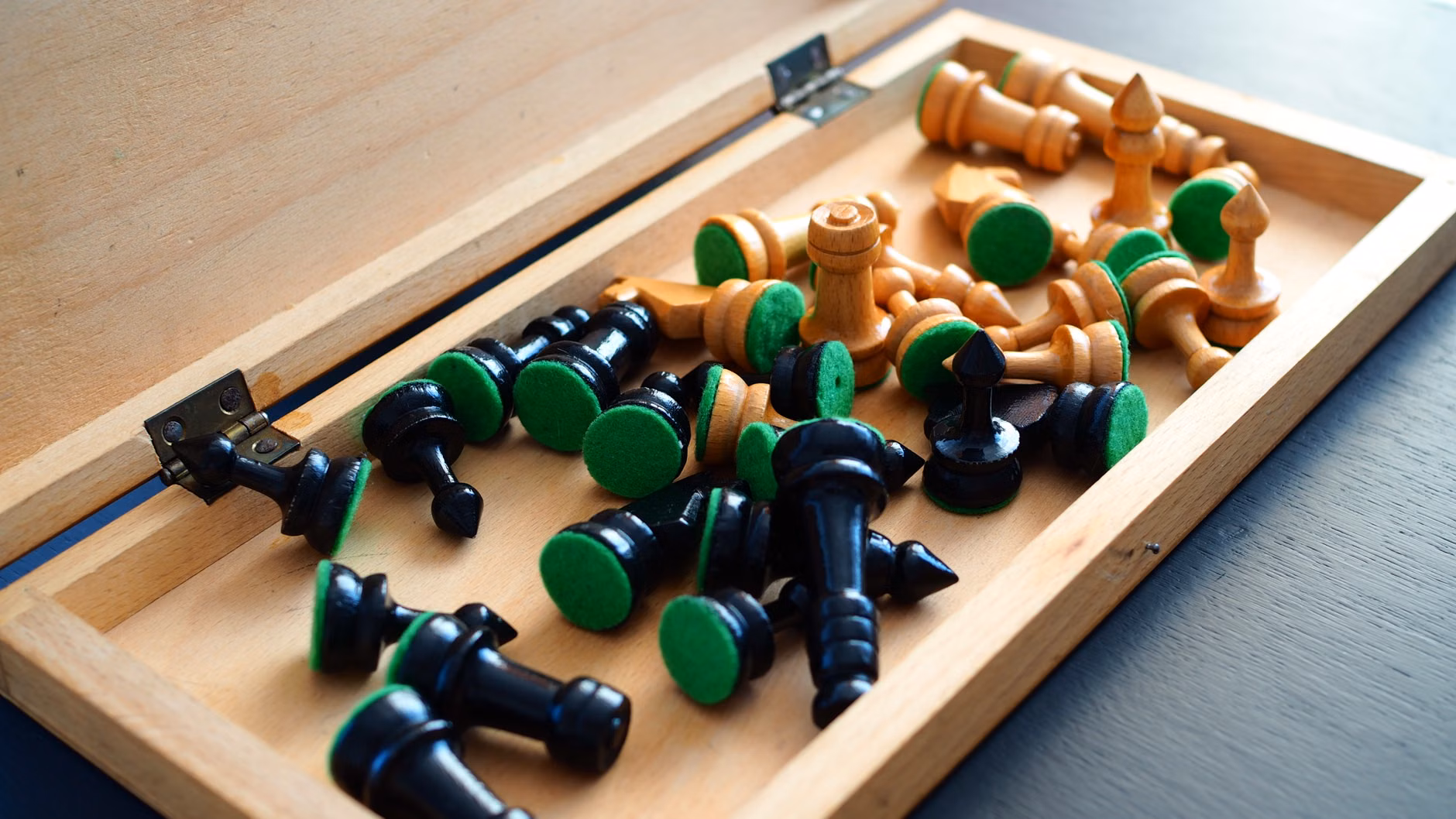 A collection of board games neatly organized on a wooden shelf.