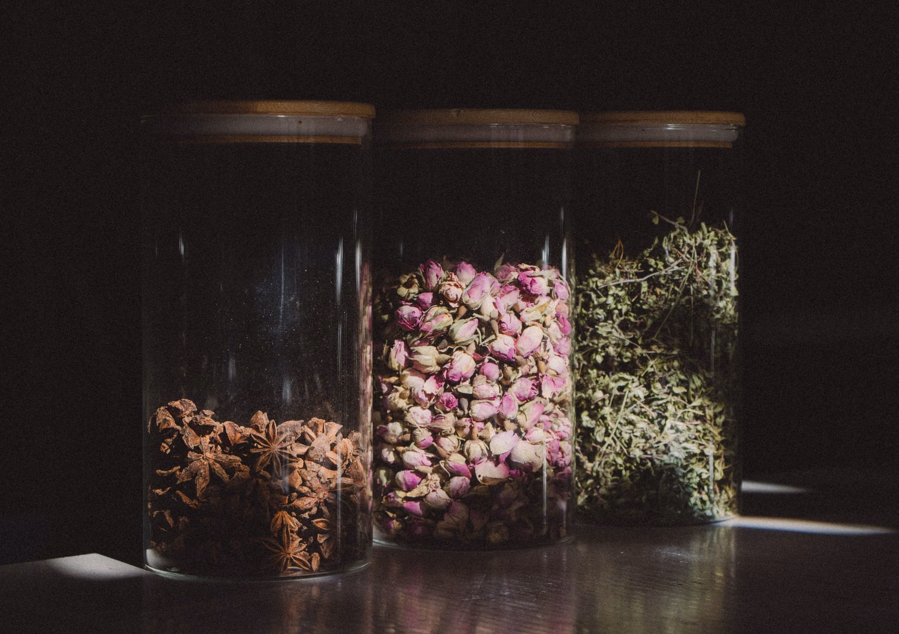 The Art of Mindful Herb Drying: A Practical Guide for Home Preservation 3 Hands labeling a glass jar of home-dried herbs for pantry storage.