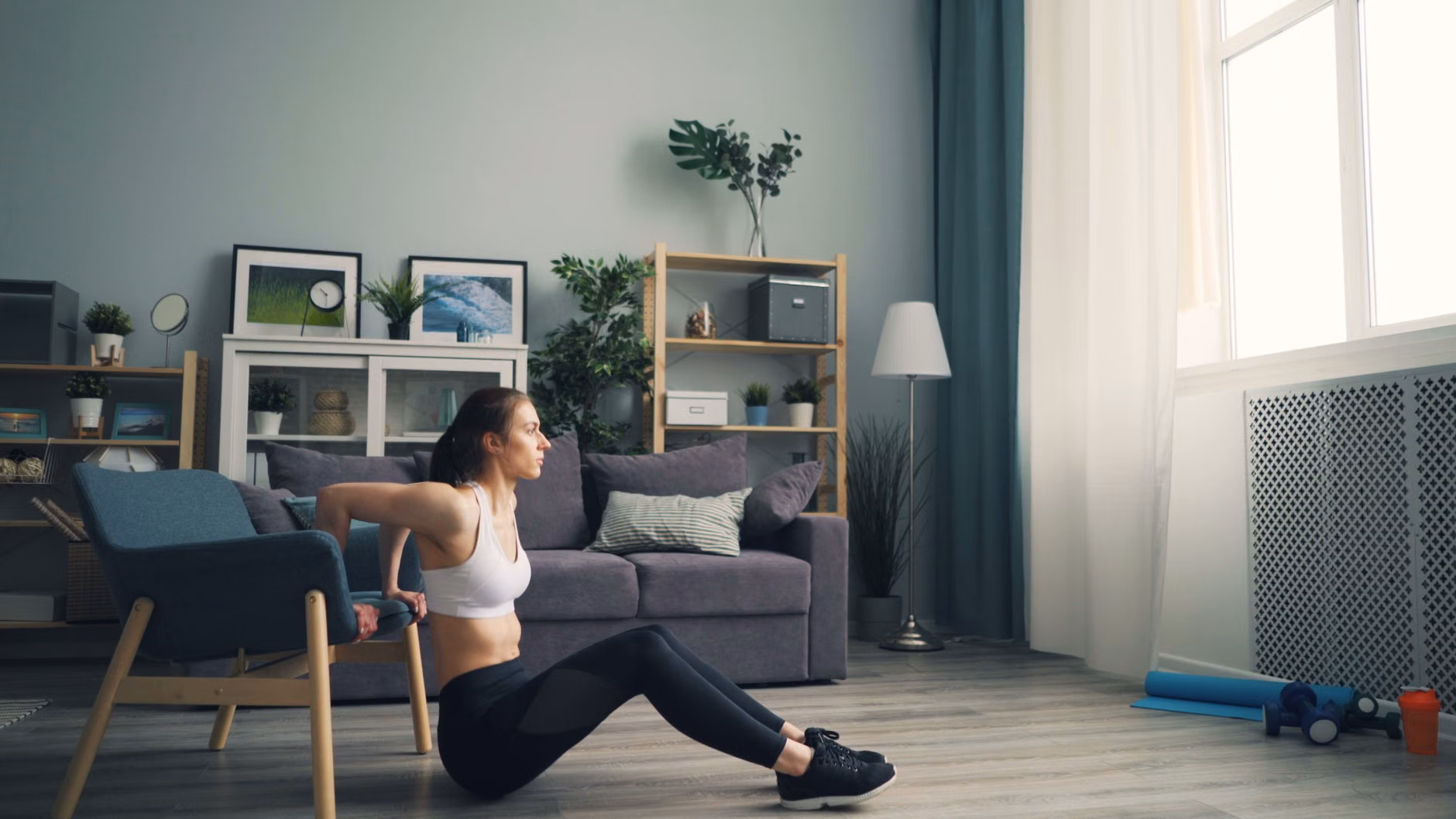 A safe home exercise setup including a sturdy chair and hydration.