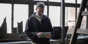 A mature adult confidently using a tablet for digital services in a bright, modern setting.