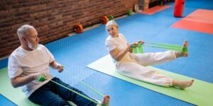 An older adult performing seated ankle exercises in a bright living room.