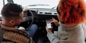 A couple planning their travel route using a smartphone in a scenic city setting.