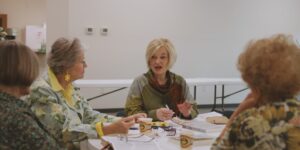 A group of older adults sharing a meal and discussing historical recipes.