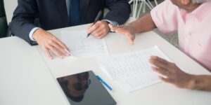 A senior individual reviewing digital financial documents on a tablet in a well-lit office.