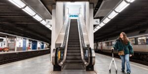 A senior couple navigating a modern, accessible train station platform.