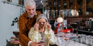 A senior couple using a smartphone to navigate a historic plaza.