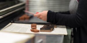 Close-up of hands working on a traditional bookbinding project.