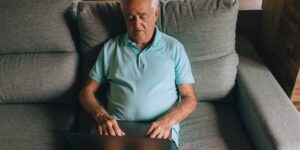 An older adult performing seated calf-raises in a home setting to improve circulation.