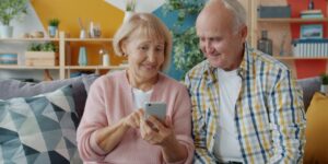 An older couple consulting a digital map on their smartphone while exploring a historic city.