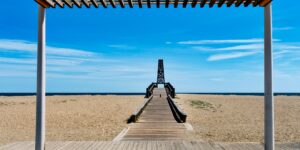 A wide, accessible wooden boardwalk along a sunny coastline, perfect for senior travelers.