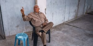 An active senior sitting in a chair practicing good posture.