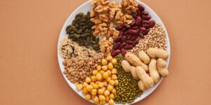 A variety of copper-rich whole foods like nuts, seeds, and shellfish arranged on a wooden table.