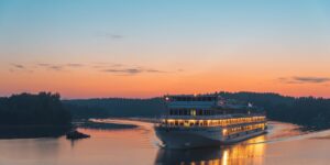 A scenic view of a river cruise ship sailing during sunset.