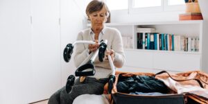 A senior traveler organizing a suitcase for a trip.
