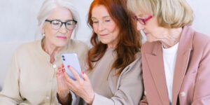 A diverse group of seniors using smartphones to navigate a modern, accessible transit station.