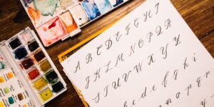 A minimalist, sunlit desk setup for calligraphy practice featuring a fountain pen and ink.