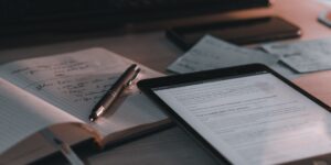 A modern home office workspace with a tablet and notebook, representing digital financial security.