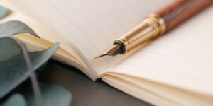 A peaceful scene of a notebook and fountain pen on a desk, representing the start of a creative writing project.