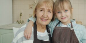 A group of older adults smiling and baking together in a community kitchen.