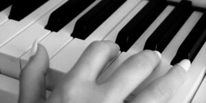 An older adult's hands on a piano keyboard, symbolizing the start of a musical journey.