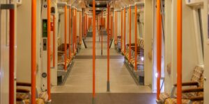 A clean, modern train carriage with priority seating and digital accessibility signage.