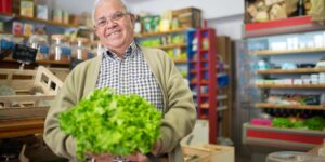 A healthy senior shopping for fresh vegetables at a local market.