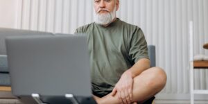 An older adult performing a seated thoracic rotation exercise for spinal health.