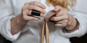 Hands of an older person practicing traditional bookbinding with needle and thread.