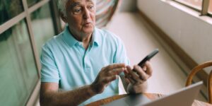 An older adult confidently using a transport app at a modern station.