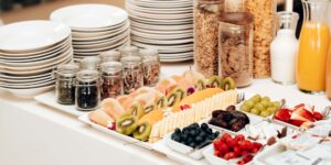 A variety of Vitamin E-rich foods including nuts, seeds, and fresh produce on a wooden table.