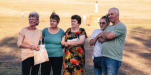 A group of older adults enjoying a community birdwatching outing in a park.