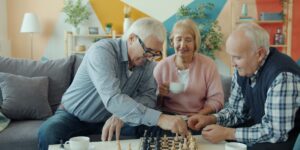 A diverse group of seniors playing chess in a bright community center.