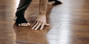 An older adult preparing to perform foot strengthening exercises in a comfortable home setting.