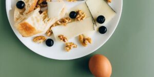 A spread of healthy, biotin-rich foods including eggs, nuts, and salmon on a wooden table.