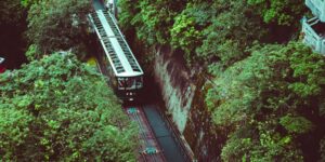 A scenic view of a historic funicular railway climbing a steep hillside in Europe.