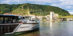 A luxurious and accessible river cruise cabin overlooking a river.