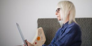A senior person confidently using a tablet in a well-lit, modern home office environment.