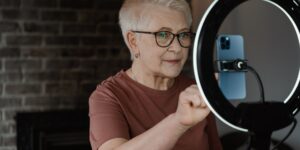 An older adult using a voice-controlled smart hub in a comfortable living room.