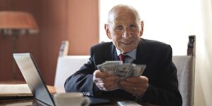 A senior adult confidently managing finances on a digital device in a home setting.