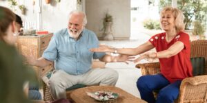 A senior and a younger adult engaging in a friendly conversation in a modern, accessible living space.