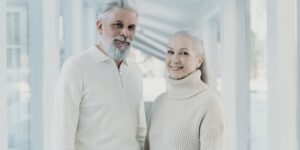 An active senior couple navigating a modern, spacious international train station.