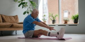 An active senior performing seated ankle exercises in a comfortable living room.