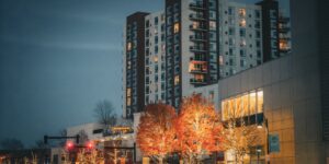 A modern, well-lit city street at dusk with warm, inviting lighting.