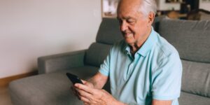 Senior adult practicing a seated torso twist for spinal mobility in a bright living room.
